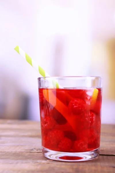 Glass of cold berry cocktail with lemon on wooden table — Stock Photo, Image