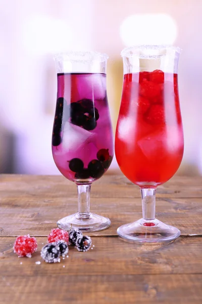 Glasses of cold berry cocktail on wooden table — Stock Photo, Image