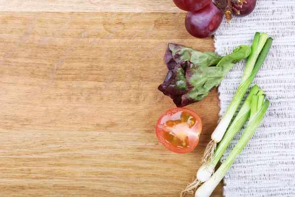 Diferentes rebanadas de verduras y bayas en mesa de madera — Foto de Stock