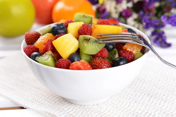 Deliciosa ensalada de frutas en plato en primer plano de mesa —  Fotos de Stock