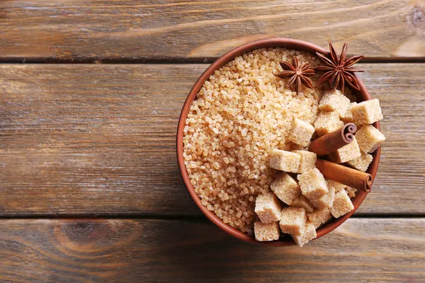 Cubes de sucre brun et sucre cristallin dans un bol sur fond en bois — Photo