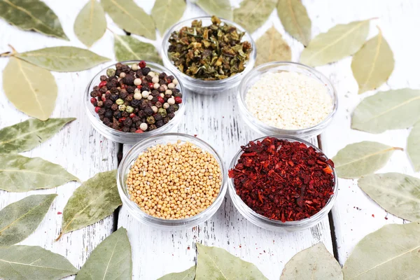 Spices with bay leaves on wooden background — Stock Photo, Image