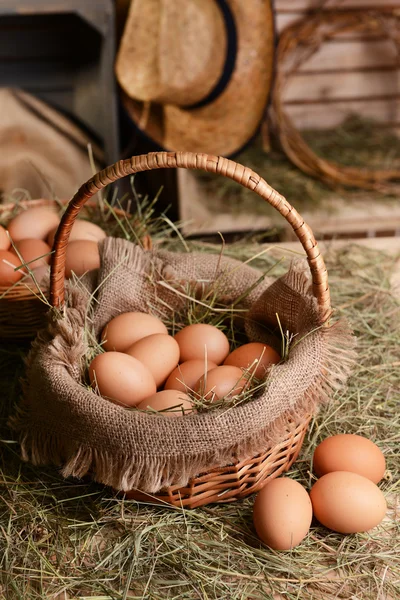 Huevos en canasta de mimbre en primer plano de la mesa — Foto de Stock