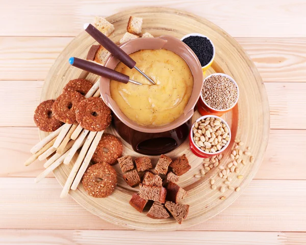 Fondue, kryddor, kex och skorpor på bamboo platta på trä bakgrund — Stockfoto