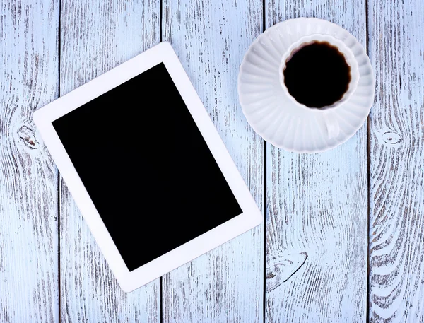 Tableta y taza de café sobre fondo de madera —  Fotos de Stock