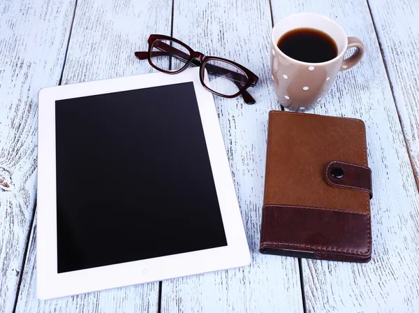 Tablet, hrnek kávy, Poznámkový blok a brýle na dřevěné pozadí — Stock fotografie