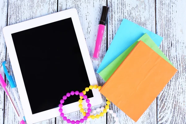 Tablet, braccialetto, notebook e penna su sfondo di legno — Foto Stock