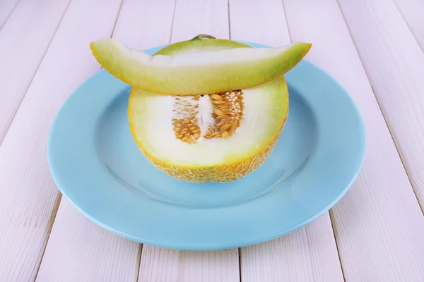 Melone auf blauem Teller auf Holzhintergrund — Stockfoto