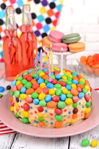Delicioso pastel de arco iris en el plato en la mesa sobre fondo brillante —  Fotos de Stock