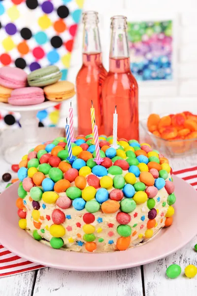 Delicioso pastel de arco iris en el plato en la mesa sobre fondo brillante —  Fotos de Stock