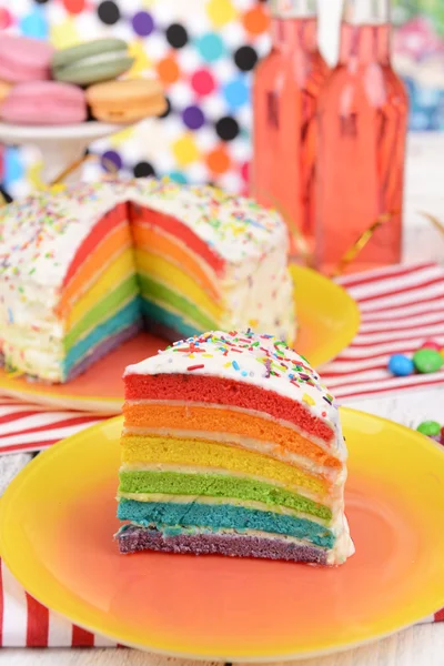 Deliziosa torta arcobaleno sul piatto sul tavolo su sfondo luminoso — Foto Stock