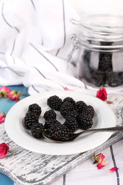 Moras dulces en plato, sobre fondo de madera de color — Foto de Stock