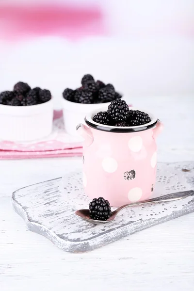 Sweet blackberries in color bowl on  bright background — Stock Photo, Image
