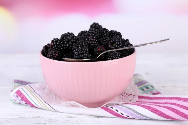 Sweet blackberries in color bowl on  bright background — Stock Photo, Image