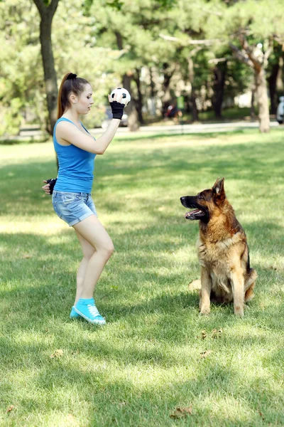 Beautiful young girl with dog in park — Stock Photo, Image