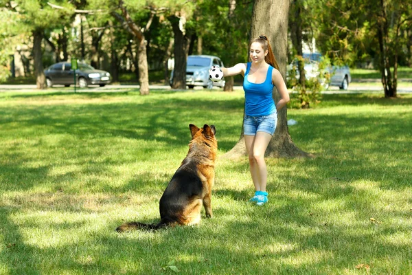 Hermosa joven con perro en el parque — Foto de Stock