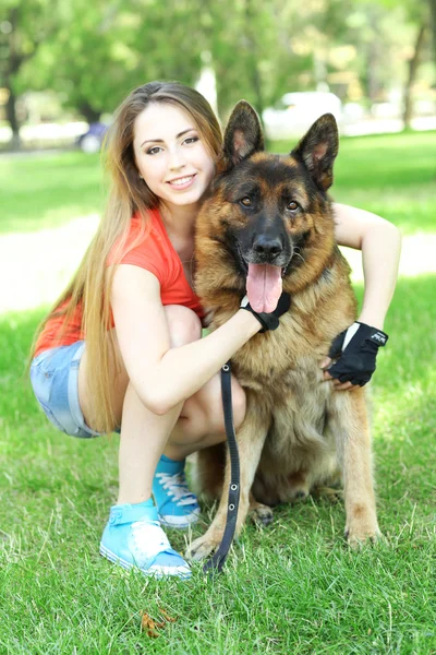 Beautiful young girl with dog in park — Stock Photo, Image