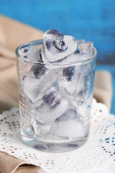 Cubos de hielo con frambuesa y arándano en vasos, sobre fondo de madera de color —  Fotos de Stock