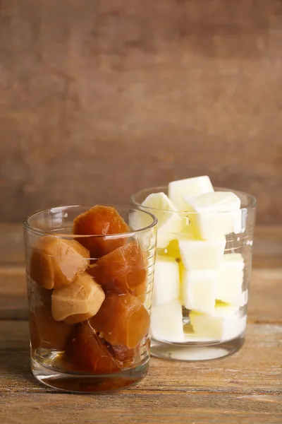 Eiskaffee und milchige Würfel in Glas auf Holzgrund — Stockfoto