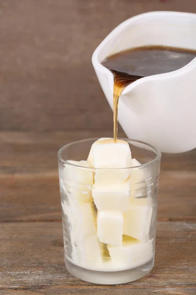 Jeges kávét, tejes jégkockák üvegből, fából készült háttér — Stock Fotó