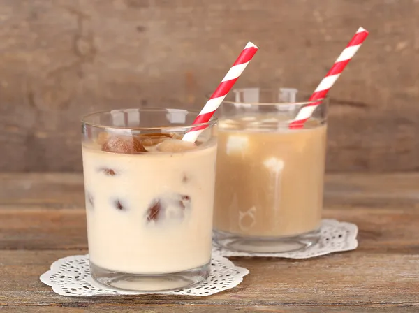 Ledová káva s mléčnou ledových kostek a studené mléko s kávou ledové kostky v brýlích na dřevěné pozadí — Stock fotografie