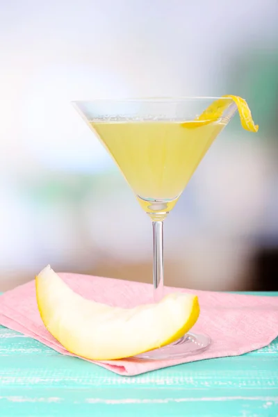 Melon smoothie in glass and melon on table on bright background — Stock Photo, Image