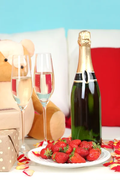 Romantische Stilleven met champagne, aardbei en bloemblaadjes van rozen close-up — Stockfoto