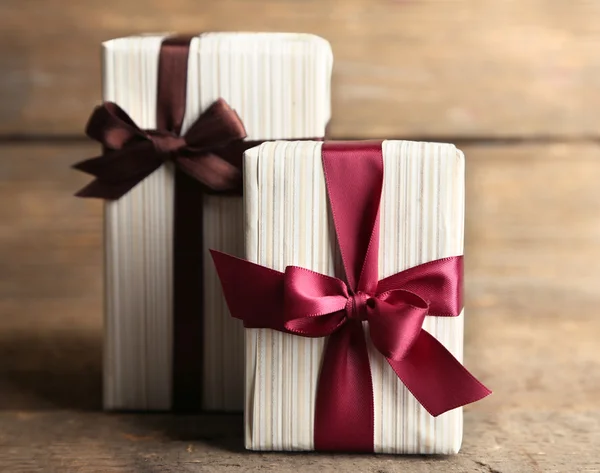 Gift boxes with colorful ribbon on wooden background — Stock Photo, Image
