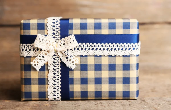 Gift box with colorful ribbon on wooden background — Stock Photo, Image