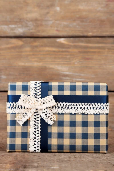 Caja de regalo con cinta de colores sobre fondo de madera — Foto de Stock