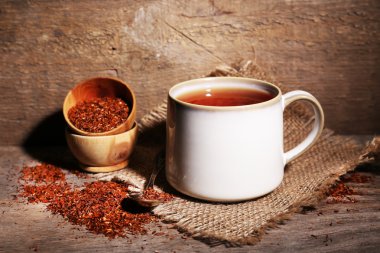 Cup of tasty rooibos tea, on wooden table clipart