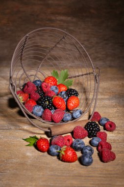 eski ahşap masa üzerinde metal sepet içinde Olgun tatlı farklı meyveler