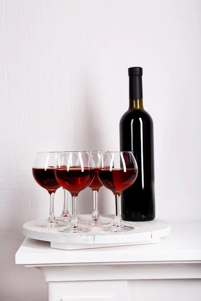 Γυαλιά και κρασί μπουκάλι στο δίσκο στο δωμάτιο — Φωτογραφία Αρχείου