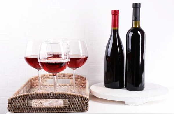 Glasses and wine bottle on tray in room — Stock Photo, Image