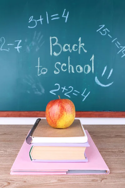 School levert op tafel op blackboard achtergrond — Stockfoto