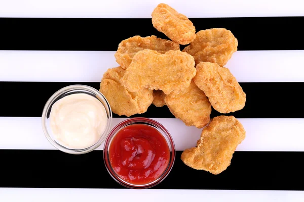 Nuggets z kurczaka smażone i sosy na tle pasiasty — Zdjęcie stockowe