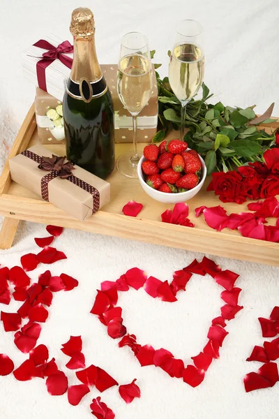 シャンパン、イチゴとバラのベッドの上でロマンチックな静物 — ストック写真