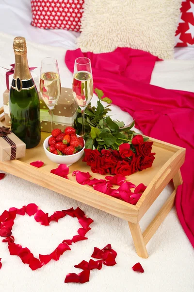 Романтичне натюрморт з шампанським, полуницею та трояндами на ліжку — стокове фото