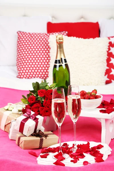 Bodegón romántico con champán, fresa y rosas en la cama —  Fotos de Stock