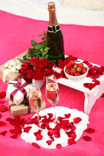 浪漫静物与香槟，草莓和玫瑰床上 — 图库照片