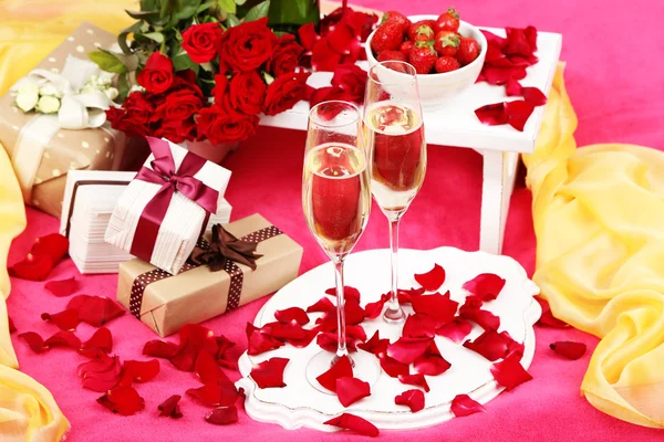 Romantic still life with champagne, strawberry and roses on bed — Stock Photo, Image