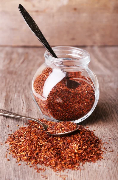 Chá rooibos seco em frasco de vidro na mesa de madeira — Fotografia de Stock