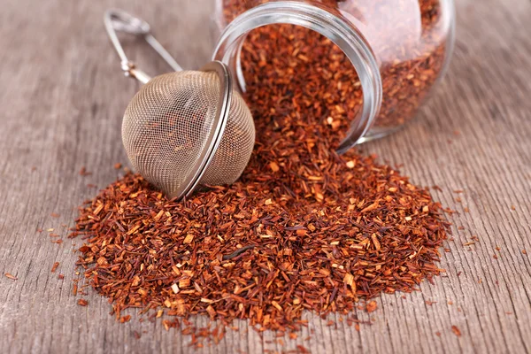 Dried rooibos tea in glass jar on wooden table — Stock Photo, Image