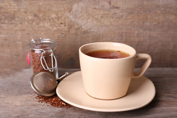 Kopje smakelijke rooibos thee, op houten tafel — Stockfoto