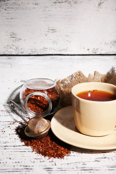 Cup of tasty rooibos tea, on old white wooden table — Stock Photo, Image