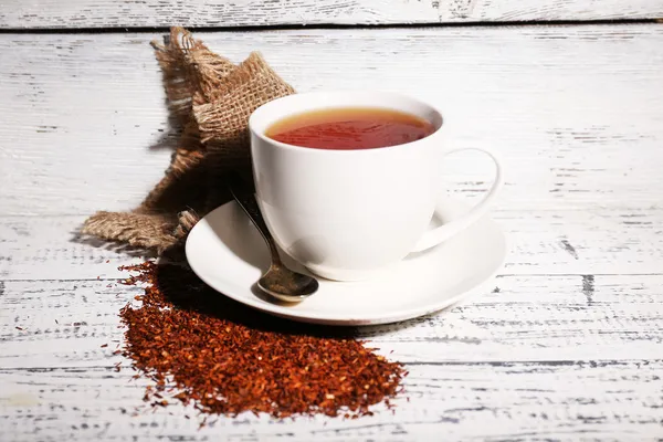 Cup of tasty rooibos tea, on old white wooden table — Stock Photo, Image