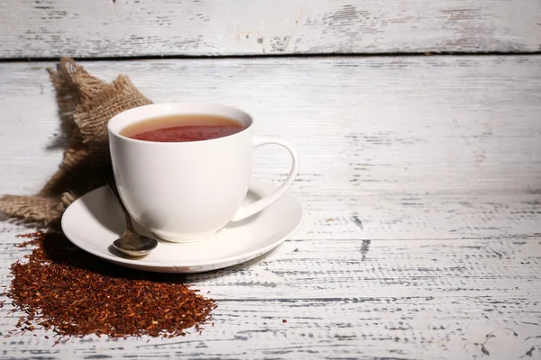 Чашка смачного чаю роїбо, на старому білому дерев'яному столі — стокове фото