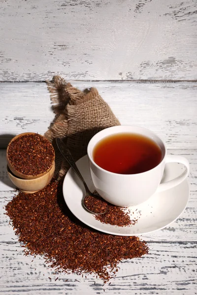 Чашка вкусного чая с ройбосом, на старом белом деревянном столе — стоковое фото