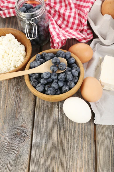 Verse bosbessen en zuivelproducten op houten tafel — Stockfoto