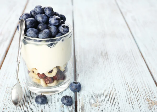 Natuurlijke yoghurt met verse bosbessen op houten tafel — Stockfoto